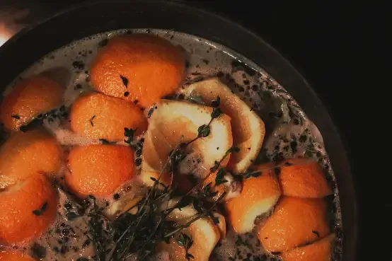 orange peels and cloves simmering in a pot of water.
